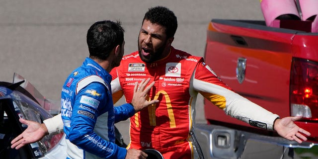 Bubba Wallace, right, argues with Kyle Larson after the two crashed during a NASCAR Cup Series auto race Sunday, Oct. 16, 2022, in Las Vegas. 