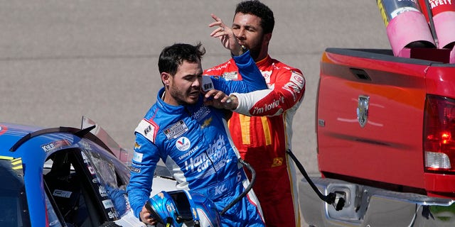 Bubba Wallace, right, pushes Kyle Larson after the two crashed during a NASCAR Cup Series auto race Sunday, Oct. 16, 2022, in Las Vegas.