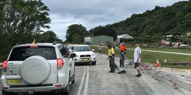 In this handout image provided by Parks Australia, members of the public and Parks Australia staff remove thousands of red crabs from a road on November 23, 2021, at Christmas Island.
