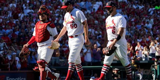 St. Louis Cardinals catcher Yadier Molina, left, starting pitcher Adam Wainwright (50) and first baseman Albert Pujols (5) walk off the field together as they are all removed at the from a baseball game against the Pittsburgh Pirates same time in the fifth inning Sunday, Oct. 2, 2022, in St. Louis.