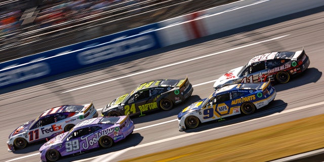Denny Hamlin, driver of the No. 11 FedEx Express Toyota, Daniel Suarez, driver of the No. 99 Tootsies Orchid Lounge Chevrolet, William Byron, driver of the No. 24 RaptorTough.com Chevrolet, Chase Elliott, driver of the No. 9 NAPA Auto Parts Chevrolet, and Cole Custer, driver of the No. 41 HaasTooling.com Ford, race during the YellaWood 500 at Talladega Superspeedway on Oct. 2, 2022, in Talladega, Alabama.