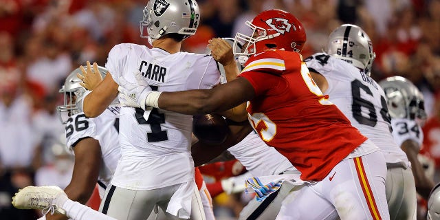 Derek Carr #4 of the Las Vegas Raiders is sacked by Chris Jones #95 of the Kansas City Chiefs during the 2nd quarter of the game at Arrowhead Stadium on October 10, 2022 in Kansas City, Missouri.
