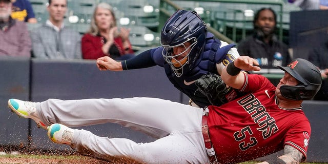 Milwaukee Brewers catcher Victor Caratini tags out Arizona Diamondbacks' Christian Walker at home during the fourth inning of a baseball game Wednesday, Oct. 5, 2022, in Milwaukee.