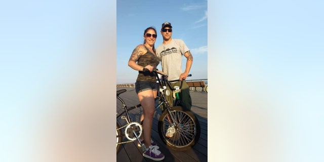 TJ Foley and Christina Sabbiondo ride bikes on a New York boardwalk.