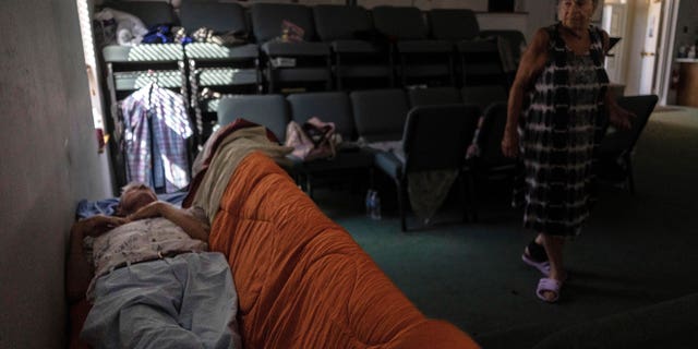 A man sleeps in the sanctuary of Southwest Baptist Church in Fort Myers, Florida, Sunday, October 2, 2022. After Hurricane Ian devastated the area, the church has become a haven for more than 10 of his parishioners.  (AP Photo/Robert Bumsted)