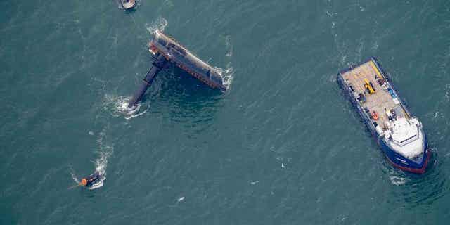 A lift boat is seen capsized seven miles off the coast of Louisiana in the Gulf of Mexico on April 18, 2021. An outage involving a Coast Guard marine warning system and "data gaps" in existing radar systems contributed to the deadly capsizing of the oil vessel..