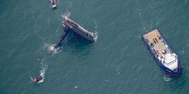A lift boat is seen capsized seven miles off the coast of Louisiana in the Gulf of Mexico on April 18, 2021. An outage involving a Coast Guard marine warning system and "data gaps" in existing radar systems contributed to the deadly capsizing of the oil vessel..