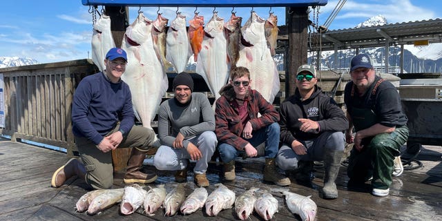 Captain John Moline, right, poses for a photo with others during the annual ASYMCA Alaska Combat Fishing Tournament on May 25, 2022, in Seward, Alaska. The tournament, which began in 2007 and now involves more than 300 soldiers, includes a day of deep-water fishing followed by a celebratory banquet with prizes for the largest catch, smallest catch and soldier who got the sickest.