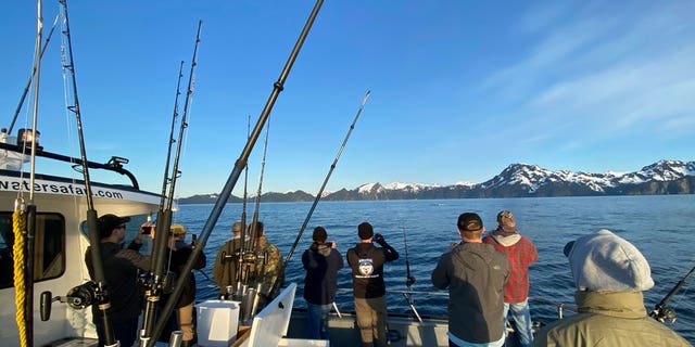 Participants, members of the armed services, and crews of the annual ASYMCA Alaska Combat Fishing Tournament are seen on May 25, 2022, in Seward, Alaska. The tournament, which began in 2007 and now involves more than 300 soldiers, includes a day of deep-water fishing followed by a celebratory banquet with prizes for the largest catch, smallest catch and soldier who got the sickest.