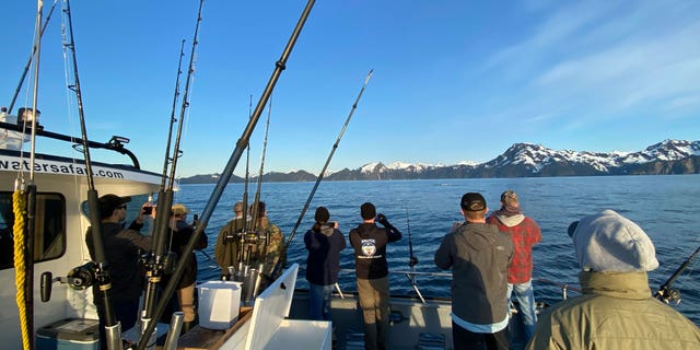 Participants, members of the armed services, and crews of the annual ASYMCA Alaska Combat Fishing Tournament are seen on May 25, 2022, in Seward, Alaska. The tournament, which began in 2007 and now involves more than 300 soldiers, includes a day of deep-water fishing followed by a celebratory banquet with prizes for the largest catch, smallest catch and soldier who got the sickest.