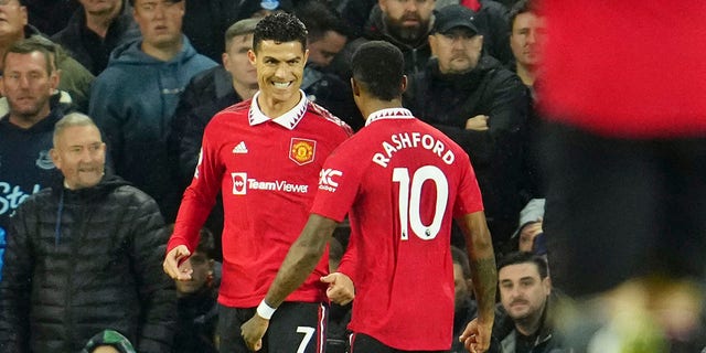 Manchester United's Cristiano Ronaldo, left, celebrates with teammate Marcus Rashford after scoring his side's second goal during a Premier League soccer match against Everton at Goodison Park in Liverpool, England, Sunday, Oct. 9, 2022. 