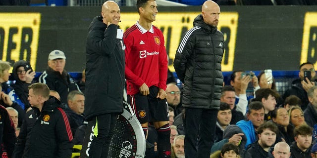 Manchester United's Cristiano Ronaldo stands next to Manchester United head coach Erik ten Hag, right, while waiting to replace teammate Anthony Martial during a Premier League soccer match against Everton at Goodison Park, in Liverpool, England, Sunday, Oct. 9, 2022.