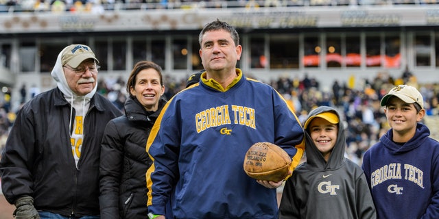 Georgia Tech beat Cumberland College 222-0 Oct. 7, 1916. Georgia Tech alumnus Ryan Schneider and his family are shown here. Schneider purchased a ball used in the game at auction in 2014 and donated it to the university. The ball, showing the score, is on display in the Edge Center, Georgia Tech athletics’ headquarters.