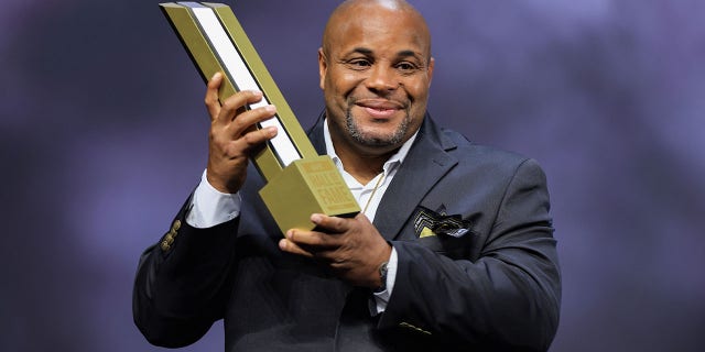 Daniel Cormier receives his trophy and jacket during the UFC Hall of Fame induction ceremony at T-Mobile Arena on June 30, 2022 in Las Vegas.