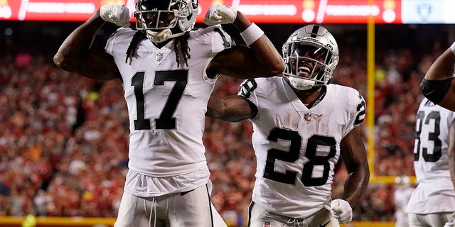 Las Vegas Raiders wide receiver Davante Adams, #17, is congratulated by Josh Jacobs, #28, after scoring during the first half of an NFL football game against the Kansas City Chiefs Monday, Oct. 10, 2022, in Kansas City, Missouri.