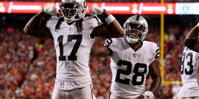 Las Vegas Raiders wide receiver Davante Adams, #17, is congratulated by Josh Jacobs, #28, after scoring during the first half of an NFL football game against the Kansas City Chiefs Monday, Oct. 10, 2022, in Kansas City, Missouri.