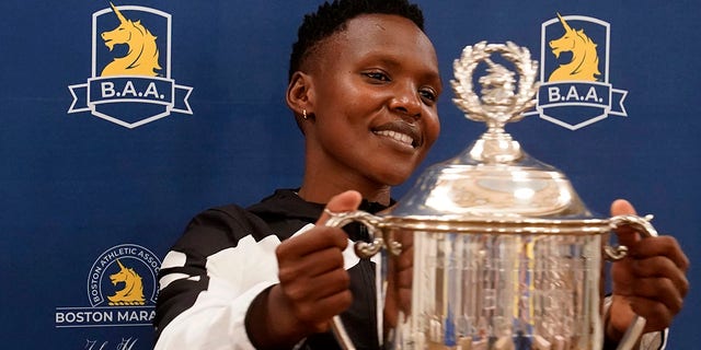 Diana Kipyokei of Kenya holds a Boston Marathon championship trophy following a news conference Oct. 12, 2021, in Boston. 
