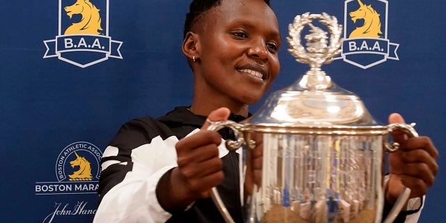 Diana Kipyokei of Kenya holds a Boston Marathon championship trophy following a news conference Oct. 12, 2021, in Boston. 