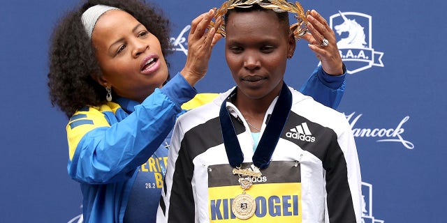 Boston Mayor Kim Janey presents Diana Kipyogei of Kenya with a golden wreath after Kipyogei won the 125th Boston Marathon Oct. 11, 2021 in Boston.