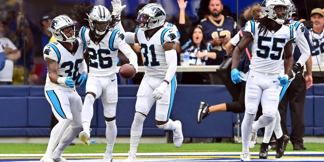 Carolina Panthers cornerback Donte Jackson (26) celebrates with cornerback Myles Hartsfield (38) and safety safety Juston Burris (31) after Jackson returned an interception for a touchdown during the first half of an NFL football game against the Los Angeles Rams Sunday, Oct. 16, 2022, in Inglewood, Calif.