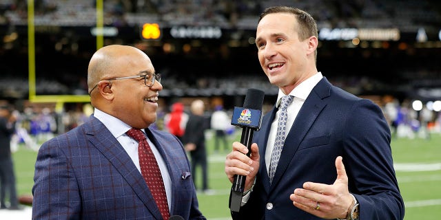 FILE - NBC Sports commentators Mike Tirico, left, and former New Orleans Saints quarterback Drew Brees broadcast from the field before a game between the Saints and Buffalo Bills on Nov. 25, 2021, in New Orleans.