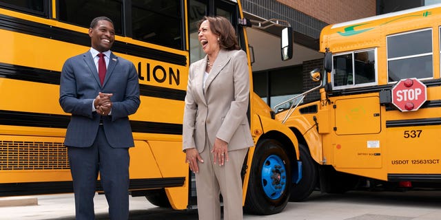 Vice President Kamala Harris laughs with Environmental Protection Agency Administrator Michael Regan during a tour of electric school buses at Meridian High School in Falls Church, Virginia, on May 20, 2022.