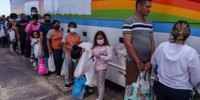 Migrants wait in line to board a chartered bus traveling to New York outside a Welcome Center in El Paso, Texas, US, on Thursday, Sept. 22, 2022. Less than two weeks before the end of the federal fiscal year, encounters between migrants and Border Patrol agents on the U.S.-Mexico border have already surpassed 2 million a new record, reports The Texas Tribune.