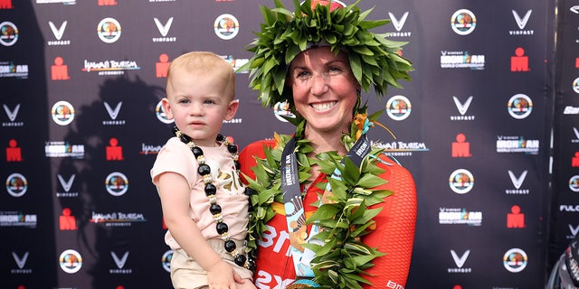 Chelsea Sodaro celebrates with her daughter Skylar after winning the Ironman World Championships on Oct. 6, 2022, in Kailua Kona, Hawaii.