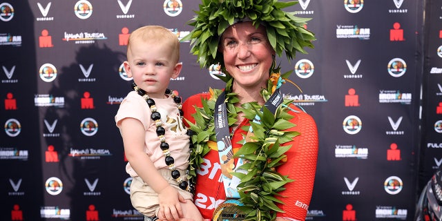 Chelsea Sodaro celebrates with her daughter Skylar after winning the Ironman World Championships on Oct. 6, 2022, in Kailua Kona, Hawaii.