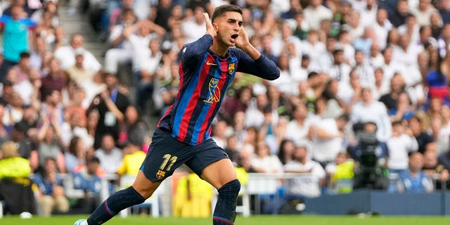 Barcelona's Ferran Torres celebrates after scoring his side's first goal during a Spanish LaLiga match between Real Madrid and Barcelona at the Santiago Bernabeu stadium in Madrid on Sunday, Oct. 16, 2022.