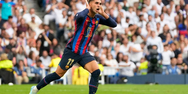Barcelona's Ferran Torres celebrates after scoring his side's first goal during a Spanish LaLiga match between Real Madrid and Barcelona at the Santiago Bernabeu stadium in Madrid on Sunday, Oct. 16, 2022.
