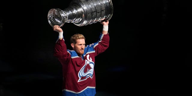 Avalanche raise Stanley Cup banner, start title defense with win 2 Colorado Avalanche left winger Gabriel Landeskog hoists the Stanley Cup for fans before the championship banner was lifted to the rafters at the team's NHL hockey game against the Chicago Blackhawks on Wednesday, Oct. 12, 2022, in Denver.