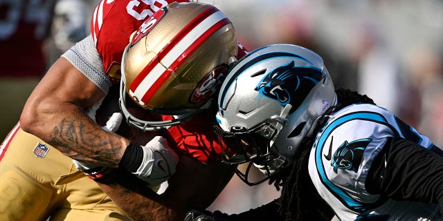George Kittle, #85 of the San Francisco 49ers, is tackled by Donte Jackson, #26 of the Carolina Panthers, during the second quarter at Bank of America Stadium on Oct. 9, 2022 in Charlotte, North Carolina.