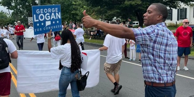 Republican Congressional nominee George Logan marches in a parade in Newtown, Connecticut, on Sept.  5, 2022 