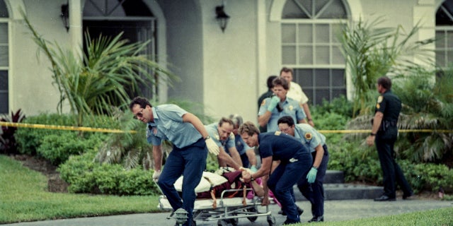 Paramedics take Marlene Warren to an ambulance on May 26, 1990, after she was shot in front of her home in Wellington, Florida.