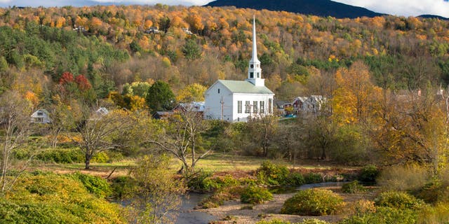 Typical New England scene: Stowe Church in a landscape of fall foliage colors in Stowe, Vermont.  The ski resort town is a powerhouse of American beer making as the home of critically acclaimed The Alchemist and Von Trapp Brewing.