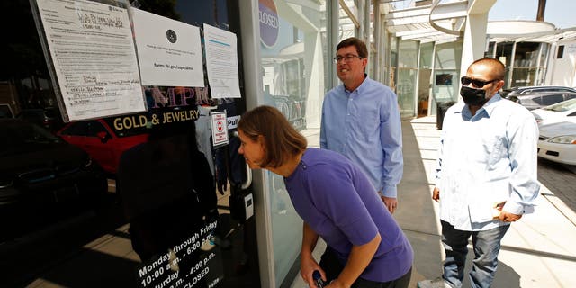 Plaintiffs Jennifer Snitko, her husband, Paul Snitko, and Joseph Ruiz, left to right, are shown outside U.S. Private Vaults on May 27, 2021, in Beverly Hills, California.