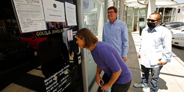 Plaintiffs Jennifer Snitko, her husband, Paul Snitko, and Joseph Ruiz, from left, are shown outside the United States Private Vaults on May 27, 2021, in Beverly Hills, California.
