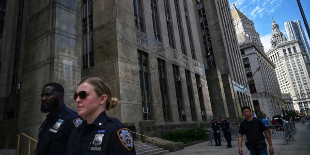 People walk past the Criminal Courts building and District Attorney's office in Manhattan in 2021.