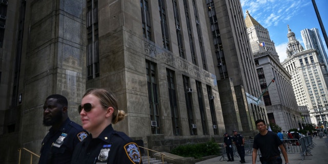 People walk past the Criminal Courts building and District Attorney's office in Manhattan in 2021.