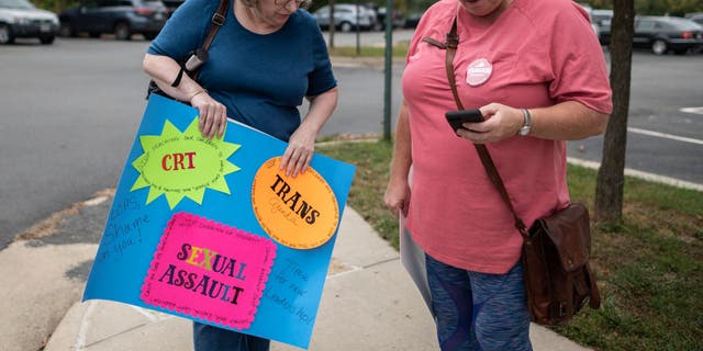 A protester holds a sign calling for Loudoun County public schools to stop promoting transgender ideology in Ashburn, Virginia on October 12, 2021. 
