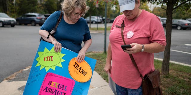 A protester holds up a sign calling on Loudoun County Public Schools to stop promoting transgender ideology on October 12, 2021 in Ashburn, Virginia.