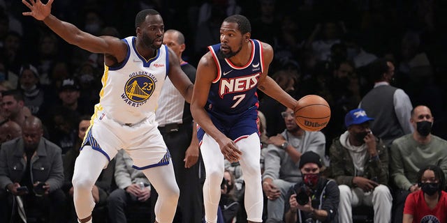 Kevin Durant (7) of the Brooklyn Nets handles the ball against Draymond Green (23) of the Golden State Warriors Nov. 16, 2021, at Barclays Center in Brooklyn, N.Y. 