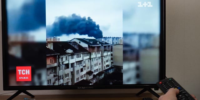 A television screen showing a news report about the shelling of the Ivano-Frankivsk airport.