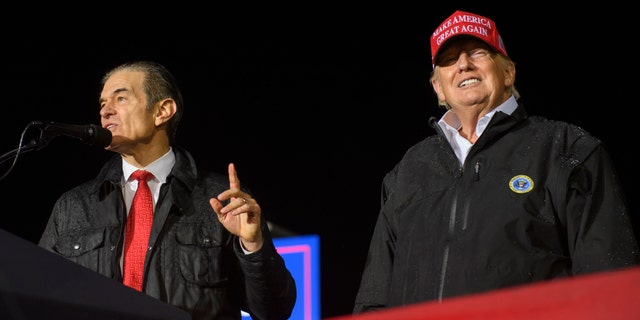 Senate candidate Dr. Mehmet Oz joins former President Donald Trump onstage during a rally at the Westmoreland County Fairgrounds in Greensburg, Pennsylvania, on May 6, 2022.