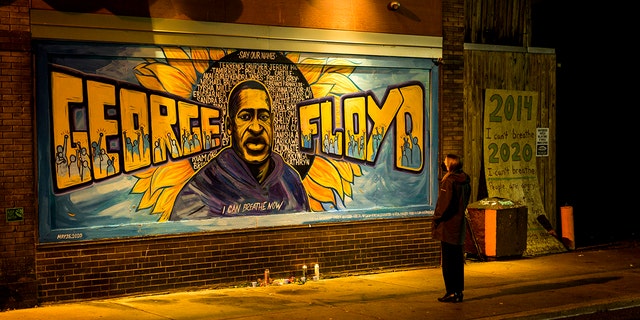 A woman looks at a mural on the wall of Cup Foods during a vigil for George Floyd on May 25, 2022 in Minneapolis, Minnesota. 
