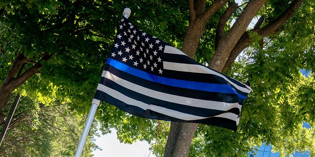 A thin blue line flag, signaling support for law enforcement, is displayed above the sign for the National Rifle Association outside its headquarters in Fairfax, Virginia, on May 31, 2022. 