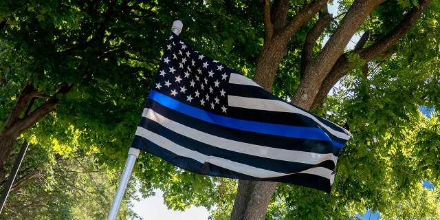 A thin blue line flag, signaling support for law enforcement, is displayed above the sign for the National Rifle Association (NRA) outside its headquarters in Fairfax, Virginia, on May 31, 2022. 