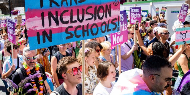 Un manifestante expresa su apoyo a la promoción de la ideología transgénero en las escuelas durante una marcha a favor de las personas transgénero.