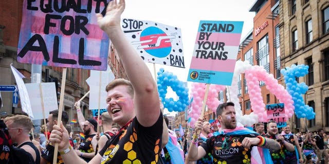 Members of the LGBTQIA+ community hold placards expressing their opinion during the Pride Parade in Manchester, England.